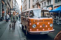 维也纳充满活力的街景中，经典橙色大众货车和行人构成了特色