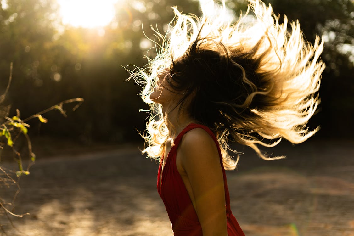 Free Woman in Red Sleeveless Top Flipping Hair Stock Photo