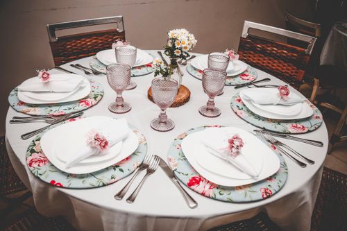 Free Beautifully arranged dining table with floral decor and elegant flatware for a special occasion. Stock Photo