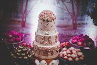 室内活动中，装饰精美的婚礼蛋糕与花卉设计包围的甜点引人注目