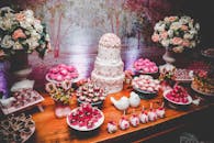 甜点桌布置精美，配有分层蛋糕、糖果和花卉