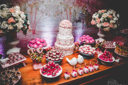 Free A beautifully arranged dessert table featuring a tiered cake, sweets, and floral arrangements. Stock Photo