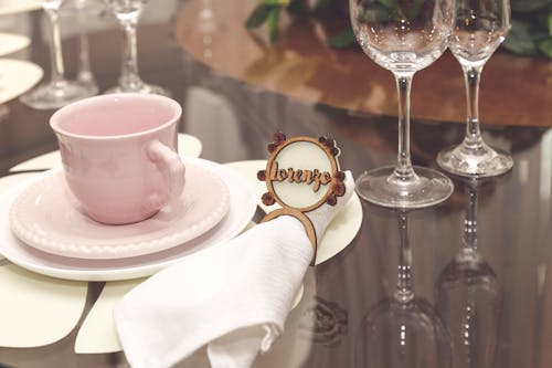 Free Pink Ceramic Cup With Saucer Besides White Napkin Stock Photo