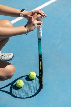 Close-up of a woman preparing for tennis on a sunny outdoor court.