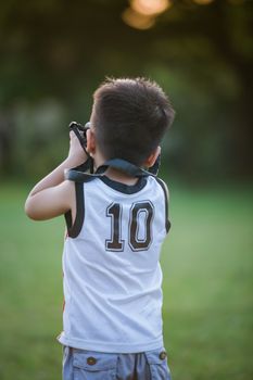 一个年幼的孩子正在绿色的户外环境中用双筒望远镜欣赏大自然
