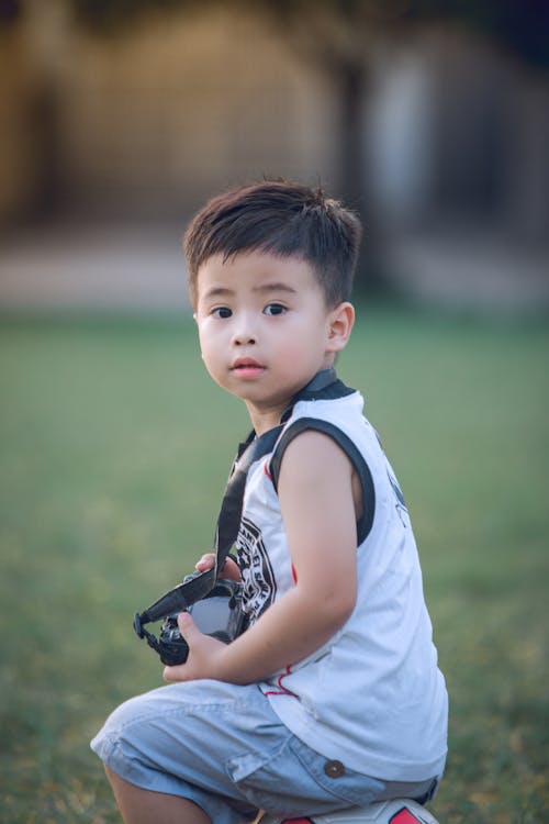 Ragazzo Seduto Sulla Palla Con Fotocamera Dslr