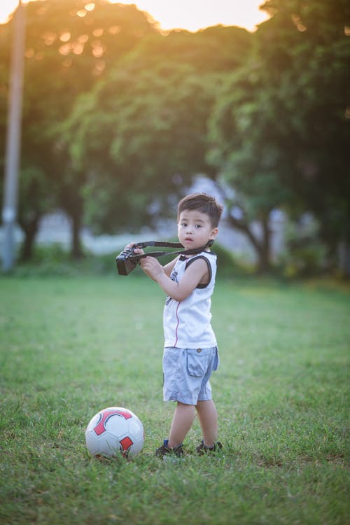 Free Boy Standing Beside Soccer Ball Stock Photo