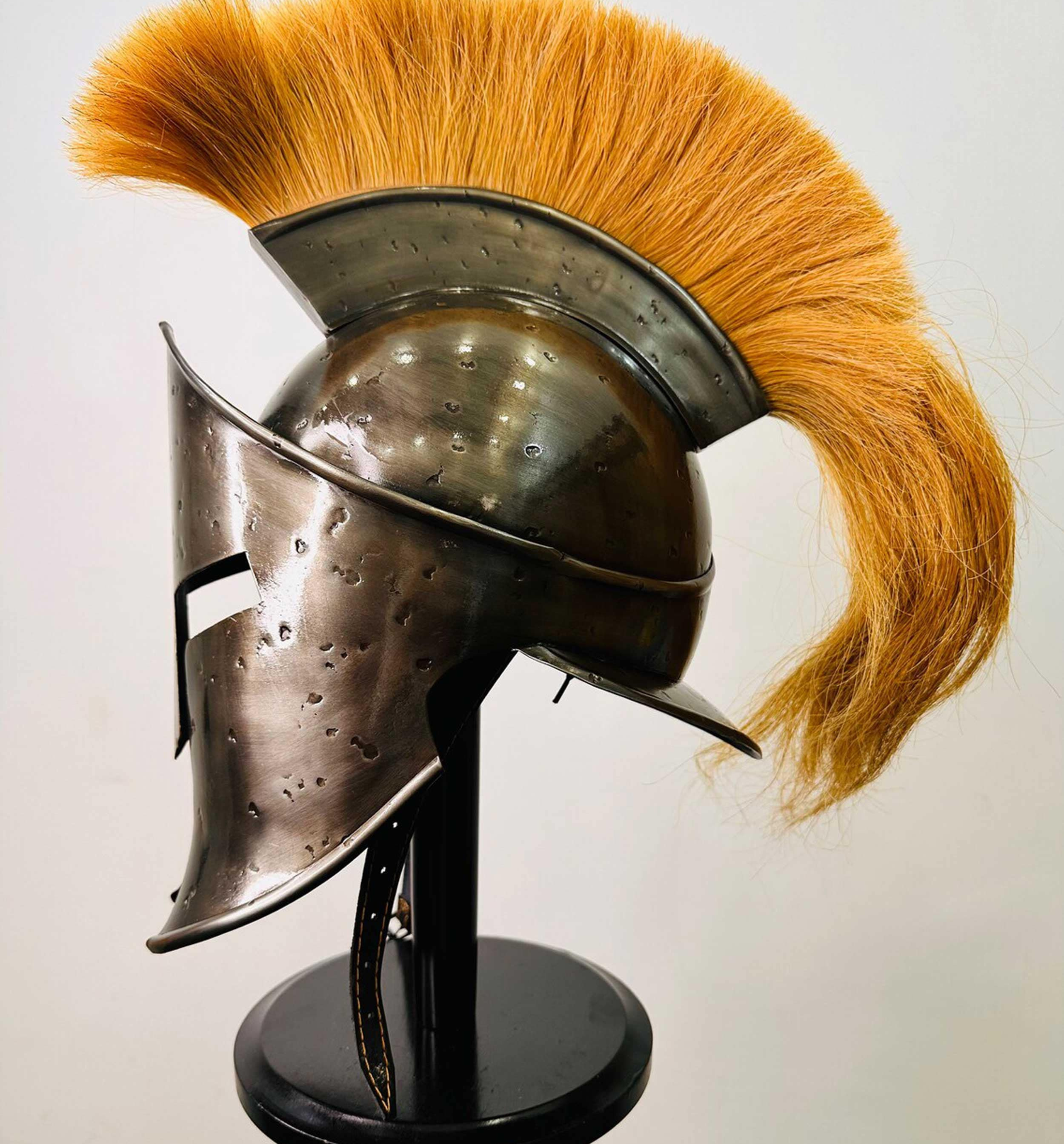 Detailed image of a handcrafted Spartan helmet with a traditional brush design.