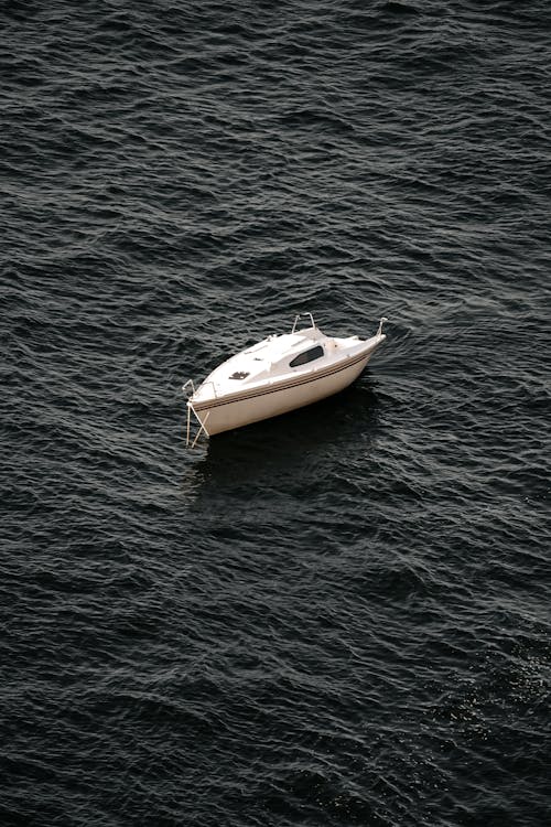 A small white boat floating in the ocean