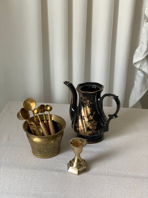 Free A vintage arrangement of brass items including a teapot and candlestick, set against a soft backdrop. Stock Photo