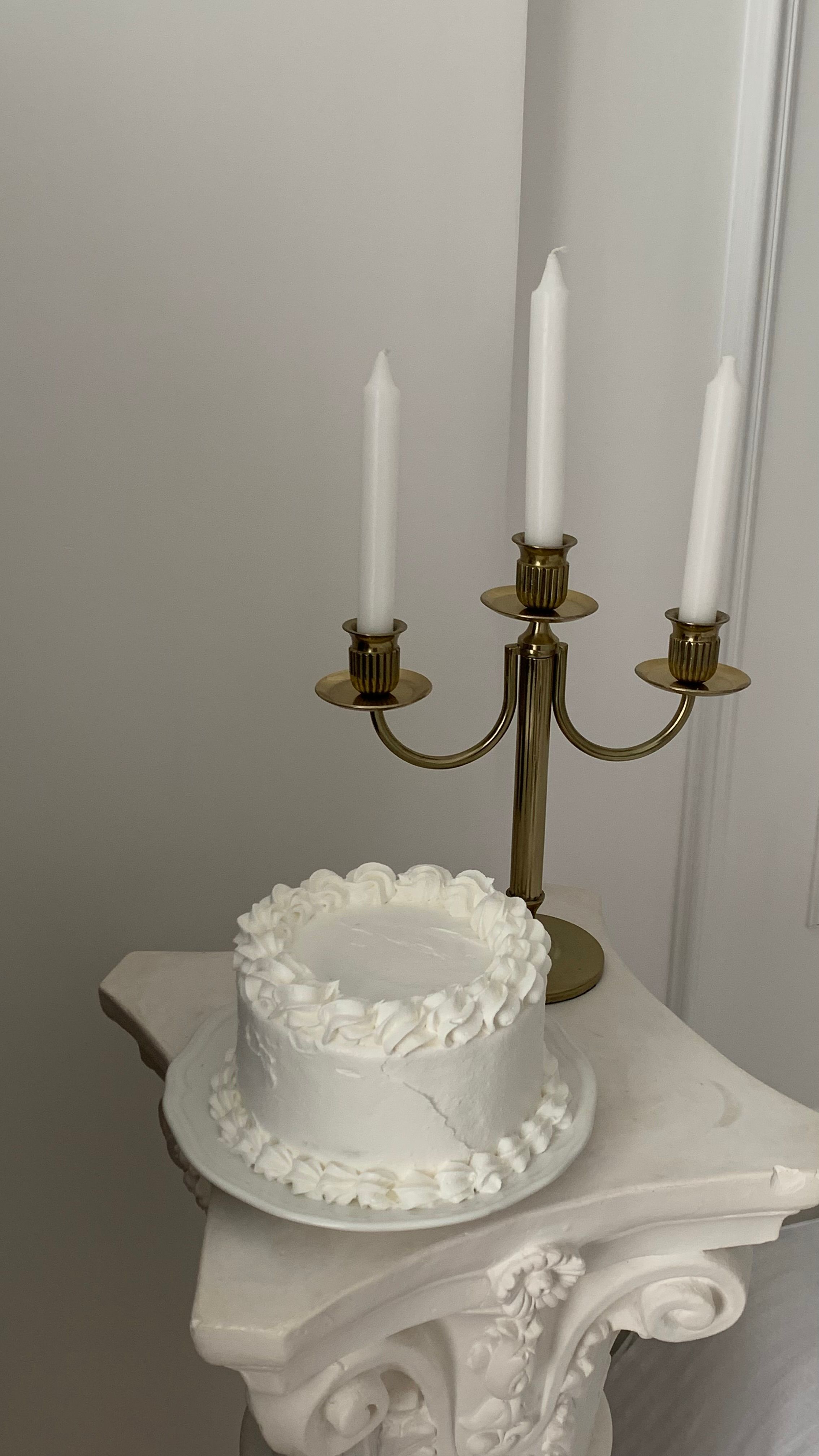 A white cake with candles on top of a pedestal · Free Stock Photo