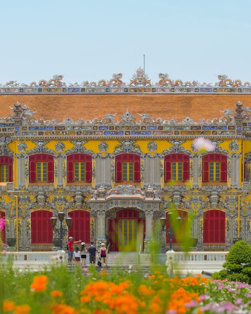 A large building with colorful flowers in front