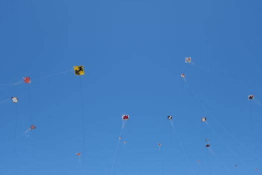 Vibrant kites soar high in the clear blue sky at Hamamatsu Kite Festival, Japan.