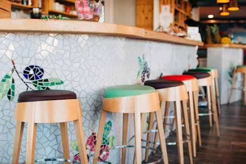 A bar with colorful stools and a mosaic tile floor