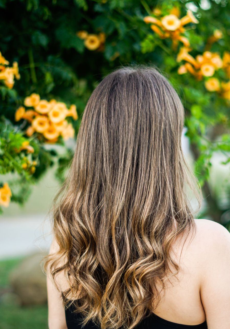 Capelli lunghi castani, luminosi, in un giardino