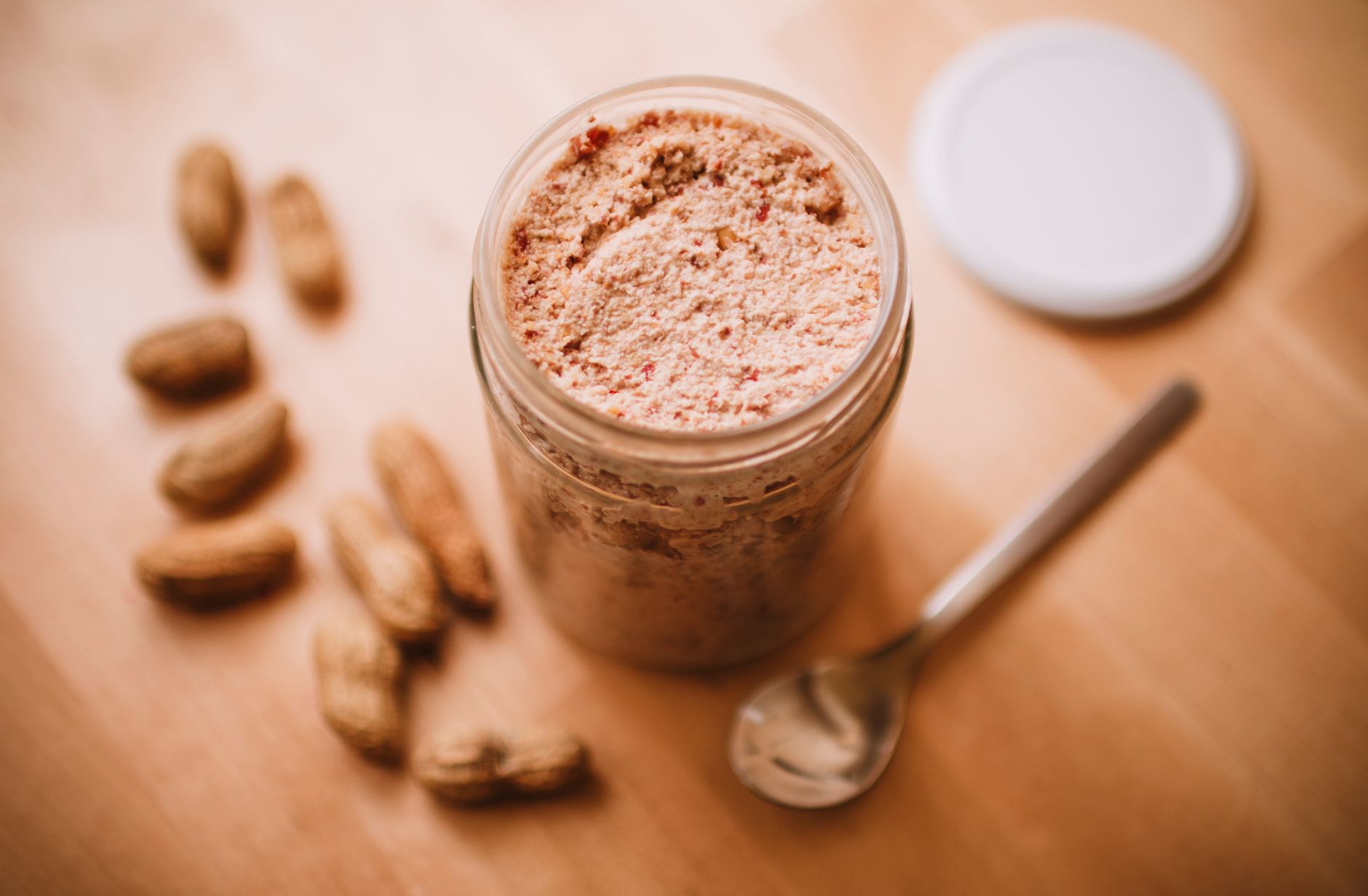 Jars of natural peanut butter on wooden table
