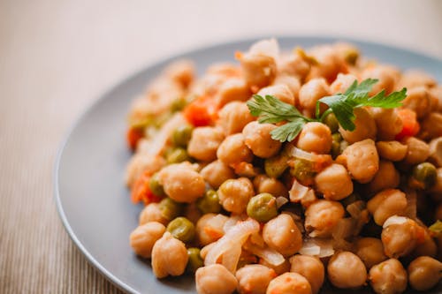 A plate of chickpeas with parsley and carrots