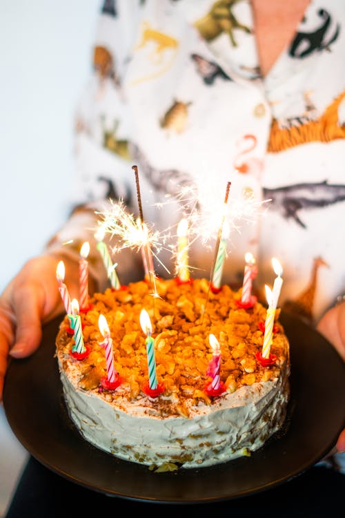 A woman holding a cake with candles on it