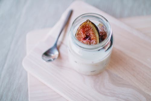 A small jar of yogurt with figs on top