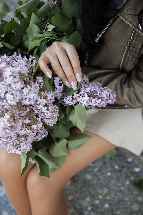 Free A woman gently holds a lilac bouquet, showcasing intricate details and natural beauty. Stock Photo