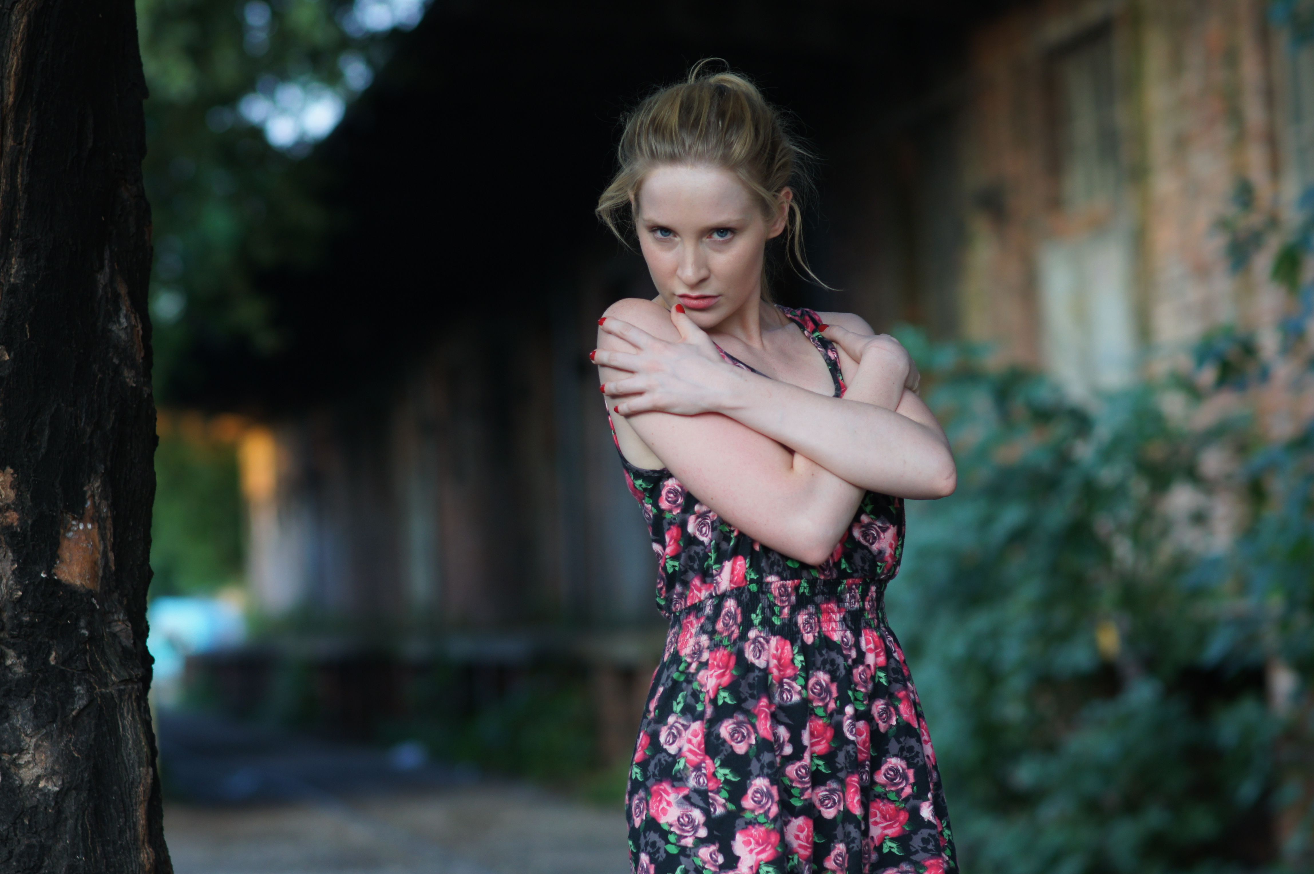 A woman in a floral dress is posing for a picture · Free Stock Photo