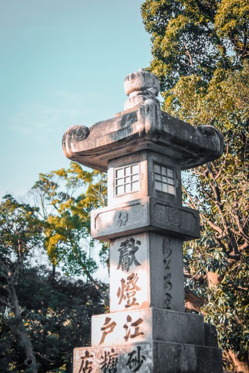 Free Close-up of a stone lantern with Japanese inscriptions in a serene temple garden setting. Stock Photo