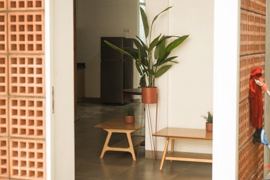 A minimalist hallway featuring modern decor, potted plants, and sleek furniture in a bright and stylish setting.