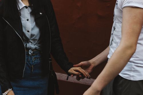 Free A couple holding hands, showcasing emotional connection against a city backdrop. Stock Photo