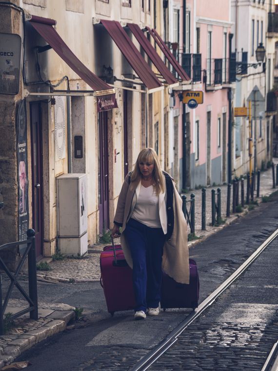 Woman traveling through a city street with luggage