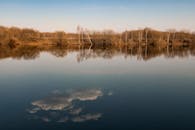 日落时分，树木和云彩倒映在宁静的湖面上