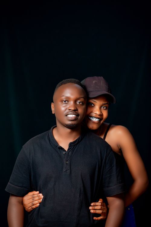 Free Affectionate studio portrait of a smiling couple against a black backdrop. Stock Photo