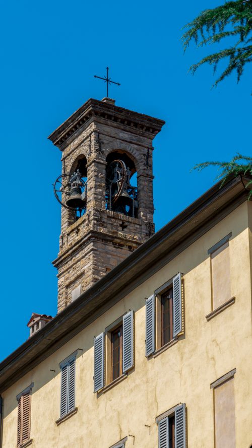 Free A beautiful historic church tower set against a clear blue sky, showcasing architectural elegance. Stock Photo