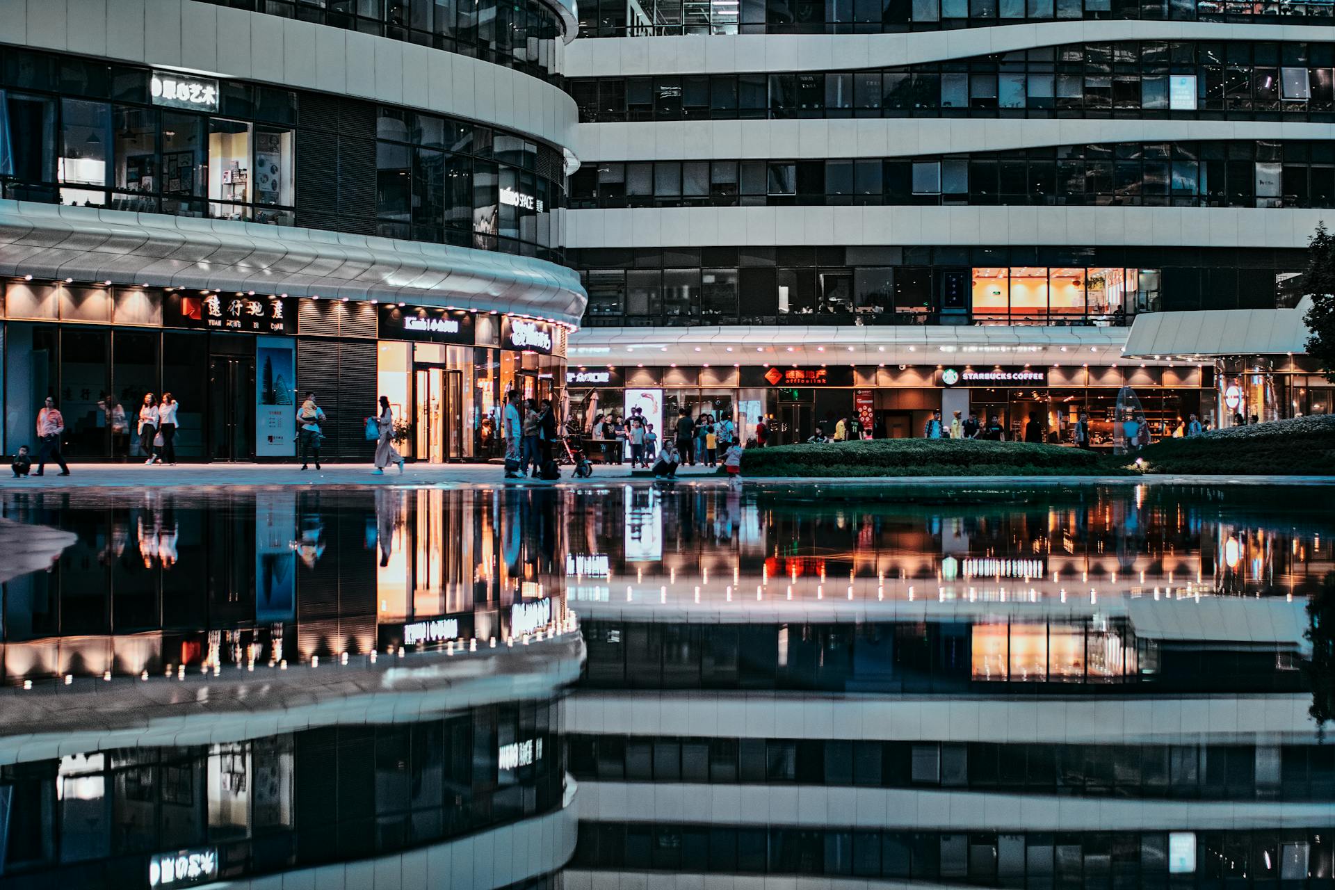 Reflective view of bustling modern architecture in Beijing, capturing urban life at night.