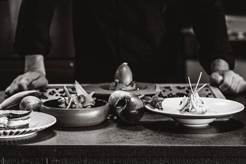 A black and white photo of a chef preparing food