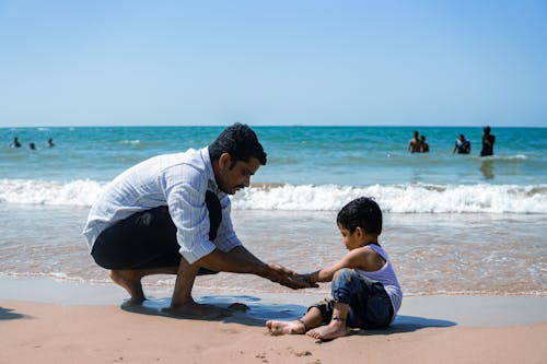 A man and a child playing on the beach