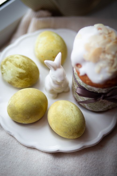 Free Decorative Easter setup with dyed eggs, ceramic rabbit, and cake on a plate. Stock Photo