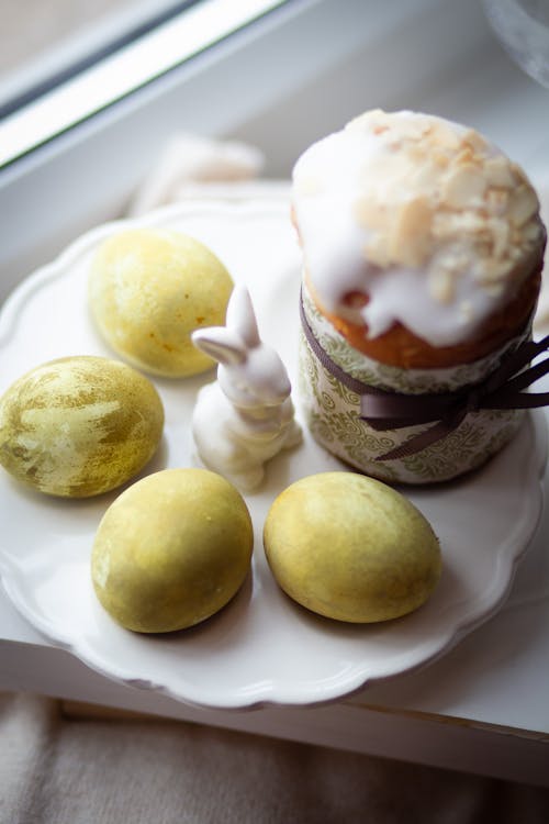 A plate with some easter eggs and a cupcake