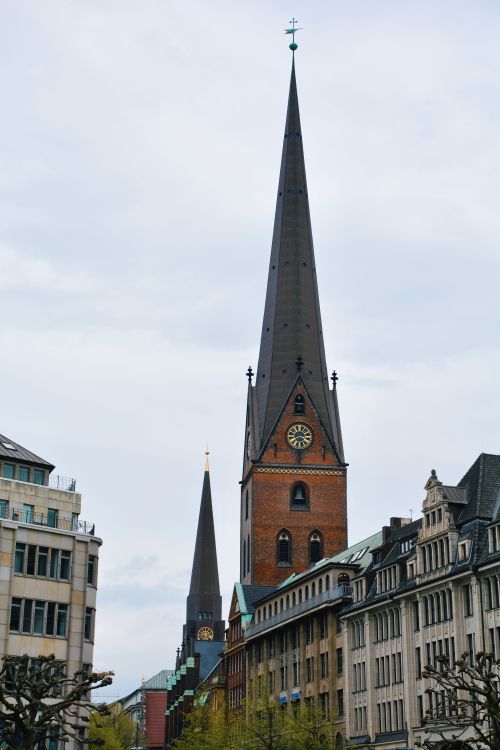 Free Gothic architecture of St. Peter's Church spire towering over urban Hamburg, Germany. Stock Photo