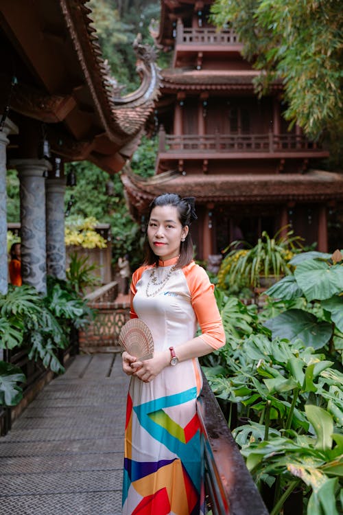 A woman in a colorful dress standing on a wooden walkway