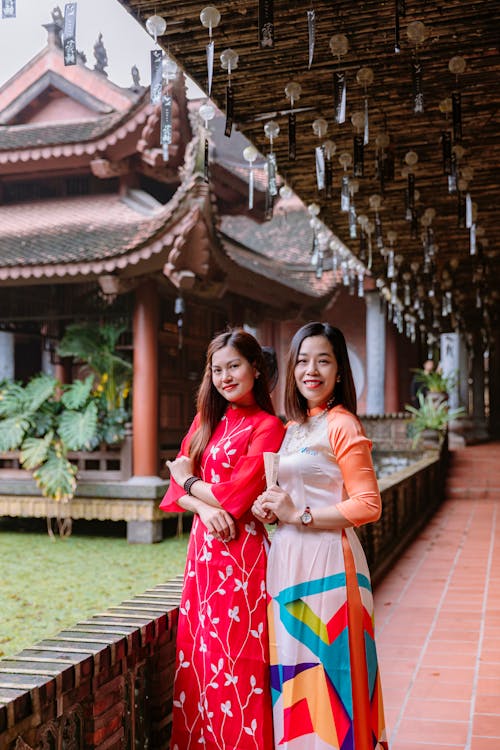 Two asian women in traditional clothing standing next to each other