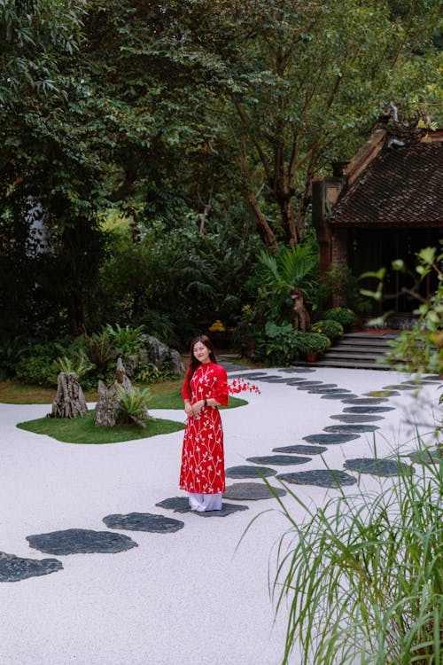 A woman in a red dress is walking on a path