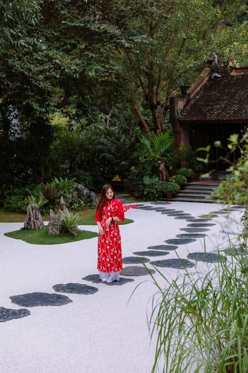 A woman in a red dress walking on a path