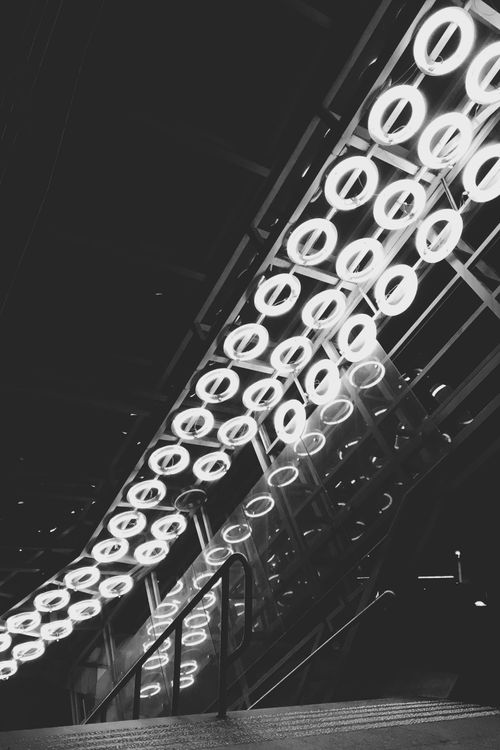 Free Artistic black and white image featuring illuminated architectural patterns with neon lights at night. Stock Photo
