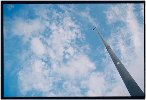 A pole with a blue sky and clouds