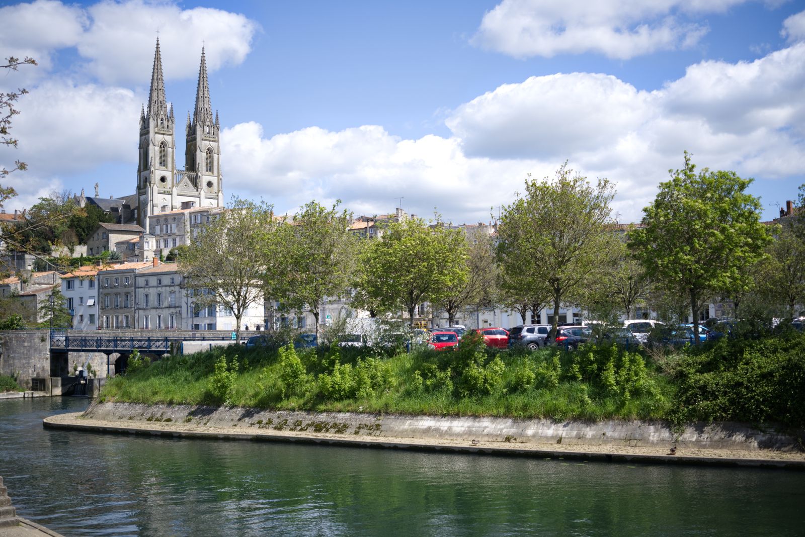 View of the Eglise Notre-Dame De Niort with the river in the foreground, in Niort, France