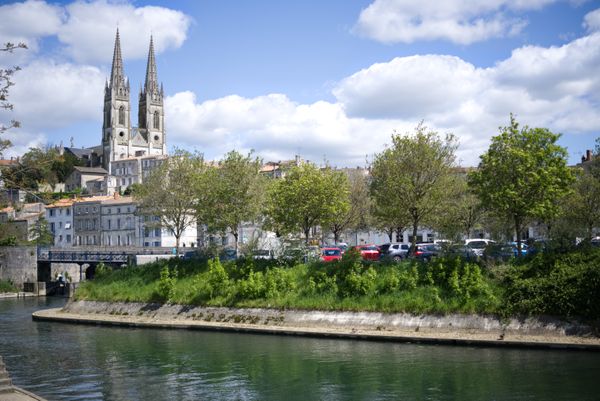 View of the Eglise Notre-Dame De Niort with the river in the foreground, in Niort, France