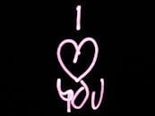 亮粉色的“我爱你”画作在黑色背景上，非常适合情人节
