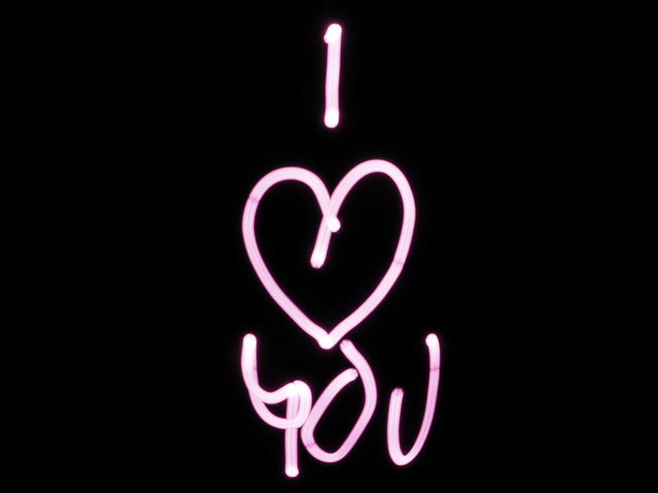bright pink light painting of i love you on a black background perfect