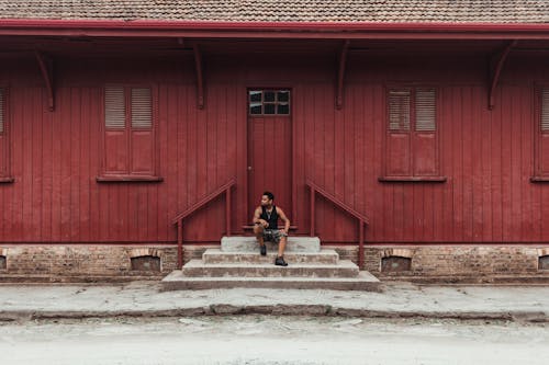 Man Sitting On A Stairway near a door