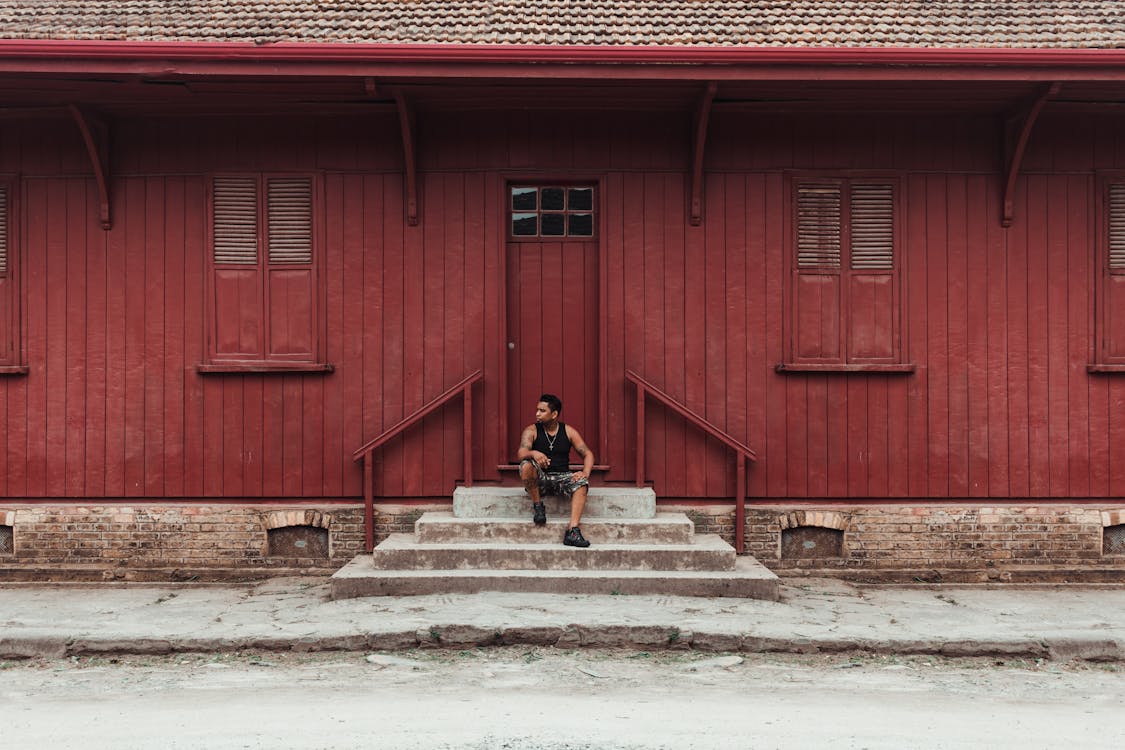 Man Sitting On A Stairway near a door